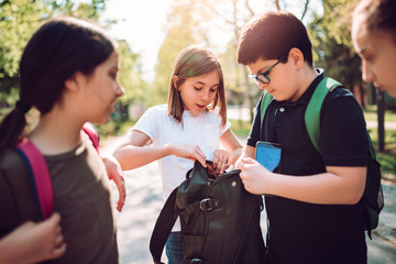 Schoolboy helping girlfriend to find smartphone