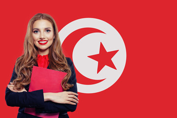 Portrait of happy woman with red book on Tunisia flag background