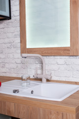 The glass is filled with tap water in the kitchen