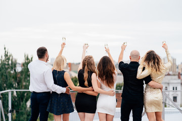 Celebration, party, birthday. Company of friends rising hands to the sky, celebrating special day. Freedom and modern youth life