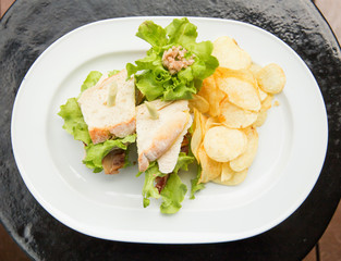 Photo of a british sandwich made with chicken, bacon, mango, tomato, cheese, and  french fries