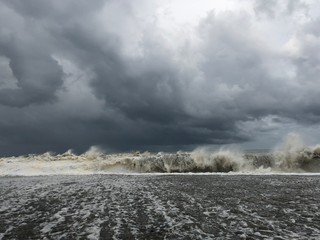 Storm at sea, storm warning on the coast. Thunderclouds and big sea waves during a storm. Restless sea during the rain. - image
