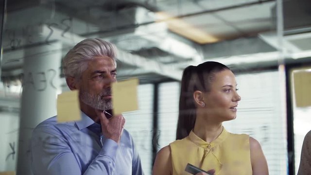 A group of business people in an office, brainstorming. Slow motion.