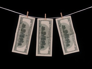 Photo takBanknotes of one hundred dollars hang on a rope with clothespins. The concept of dirty...