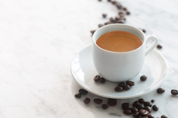 Hot cup of espresso or americano coffee in a traditional white cup on a table
