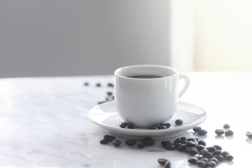 Hot cup of espresso or americano coffee in a traditional white cup on a table