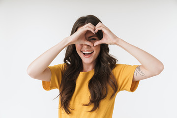 Image of beautiful brunette woman wearing casual clothes smiling and showing heart shape with fingers