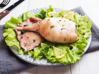 Boiled whole squid on a plate. Seafood.