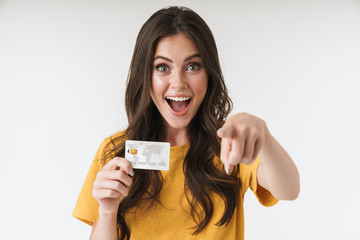 Image of pleased brunette woman wearing casual clothes pointing finger at camera and holding credit...