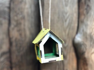 Birdhouse on a tree in the park. Bird feeder hanging on a tree. Against the background of green forest. House for birds and squirrels hanging on a tree. - image