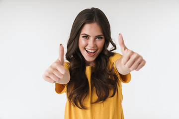 Image of excited brunette woman wearing casual t-shirt smiling and showing thumbs up