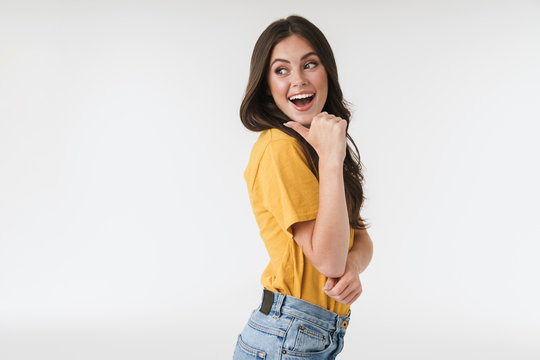 Image of young brunette woman wearing casual clothes laughing and pointing finger at copyspace