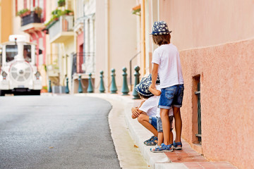 Obraz na płótnie Canvas Children walking on a narrow street with houses in Monaco-Ville, Monaco on a cloudy day