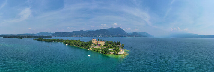 Unique view of the island of Garda. In the background is the Alps. Resort place on Lake Garda north of Italy. Aerial photography.