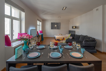 Table with crockery in modern studio apartment