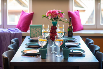 Close-up of served table in living room. Wine glasses with water.