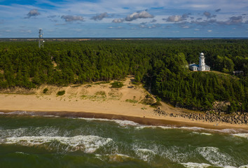 Fototapeta na wymiar Top view of the sea and the Uzhava lighthouse. Blue sky. Green forest.