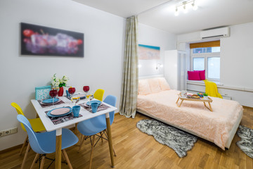 Modern interior of spacious bedroom with served table