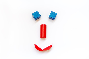 smileys of smile and sadness made up of wooden red and blue cubes, close up