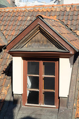 Attic window on the roof of red roof tiles.