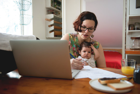 Working Mom With Baby In A Lap