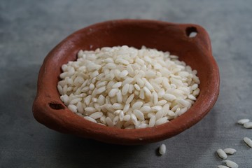 Raw Arborio rice in a bowl still life background