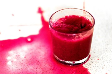 Pouring smoothie into glass, dirty background.
