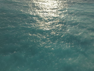 Top View Slow motion looping c ripples and wave, Refraction of sunlight top view texture sea side, Foaming and Splashing in the Ocean, Sunny Day, Slow Motion. Halkidiki, Greece. Veiw from drone