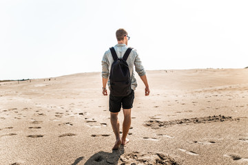 Male hiker in desert sand dunes off Denmark Skagen