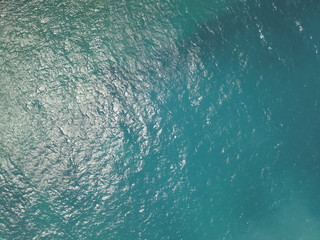 Top View Slow motion looping c ripples and wave, Refraction of sunlight top view texture sea side, Foaming and Splashing in the Ocean, Sunny Day, Slow Motion. Halkidiki, Greece. Veiw from drone