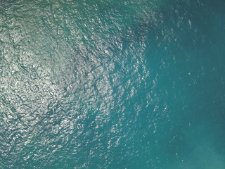 Top View Slow motion looping c ripples and wave, Refraction of sunlight top view texture sea side, Foaming and Splashing in the Ocean, Sunny Day, Slow Motion. Halkidiki, Greece. Veiw from drone