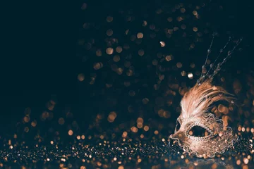 Gordijnen Luxe Venetiaans masker op donkere godlen bokeh achtergrond. Nieuwjaar en kerstfeest viering ontwerp banner. © hitdelight