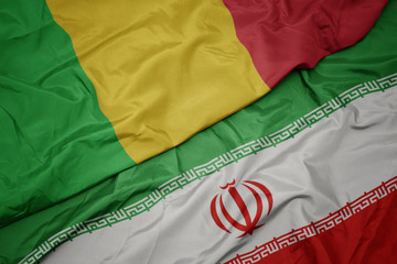 waving colorful flag of iran and national flag of mali.