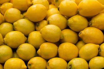 A pile of lemons at the vegetable market. Macro background of citruses.