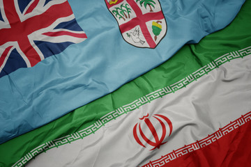 waving colorful flag of iran and national flag of Fiji .
