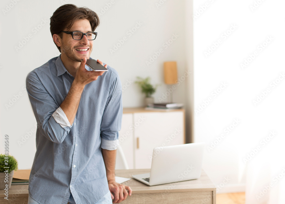 Aufkleber man using voice assistant on phone at workplace
