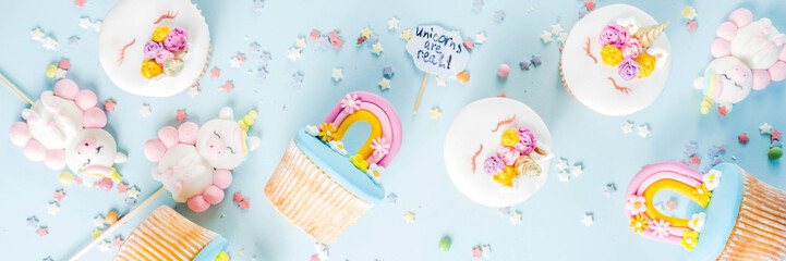 Cute unicorn and rainbow cupcakes, light blue background, copy space © ricka_kinamoto