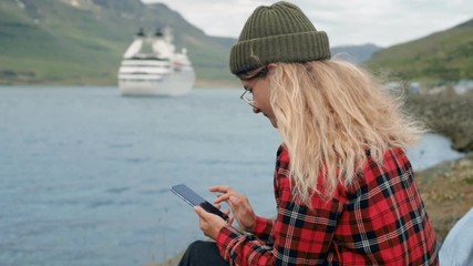 Young woman sits in port watch cruise ship leave