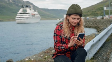 Young woman sits in port watch cruise ship leave