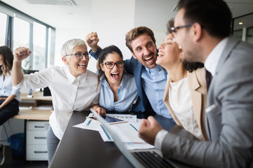 Happy business people celebrating success at company