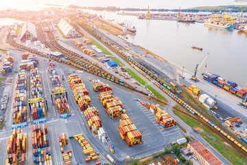 Panoramic aerial top view from the heights of the cityscape port harbor and industrial area, container warehouse and railway system network leading to the seaport.