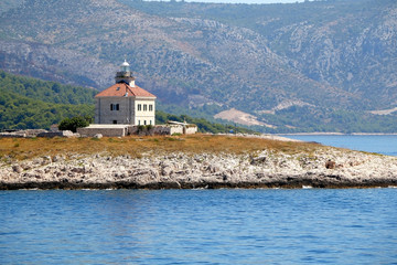 Fototapeta na wymiar Picturesque lighthouse on a small island near town Hvar, on island Hvar, Croatia.