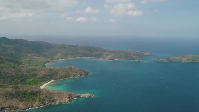 Aerial view coastline with tropical beach, island Limbones, lagoons and coral reefs. Neela cove, Philippines, Luzon. Coast ocean with turquoise water. Tropical landscape in Asia.