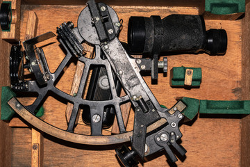 An old sextant laying down in a wooden case. Marine navigation and Columbus day concept.