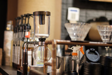 Coffee brewer machine with glass and water at a cafe shop bar