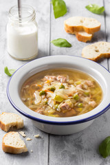 Vegetable soup with cabbage, meat, potatoes, zucchini, carrots, green peas, sour cream and bread. Delicious lunch, traditional first course, Russian