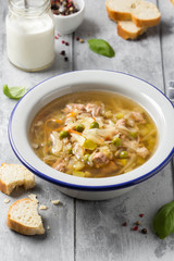 Vegetable soup with cabbage, meat, potatoes, zucchini, carrots, green peas, sour cream and bread. Delicious lunch, traditional first course, Russian