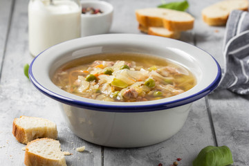 Vegetable soup with cabbage, meat, potatoes, zucchini, carrots, green peas, sour cream and bread. Delicious lunch, traditional first course, Russian