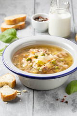 Vegetable soup with cabbage, meat, potatoes, zucchini, carrots, green peas, sour cream and bread. Delicious lunch, traditional first course, Russian