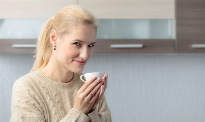 Close-up portrait of a beautiful mid age woman with cup of coffee.